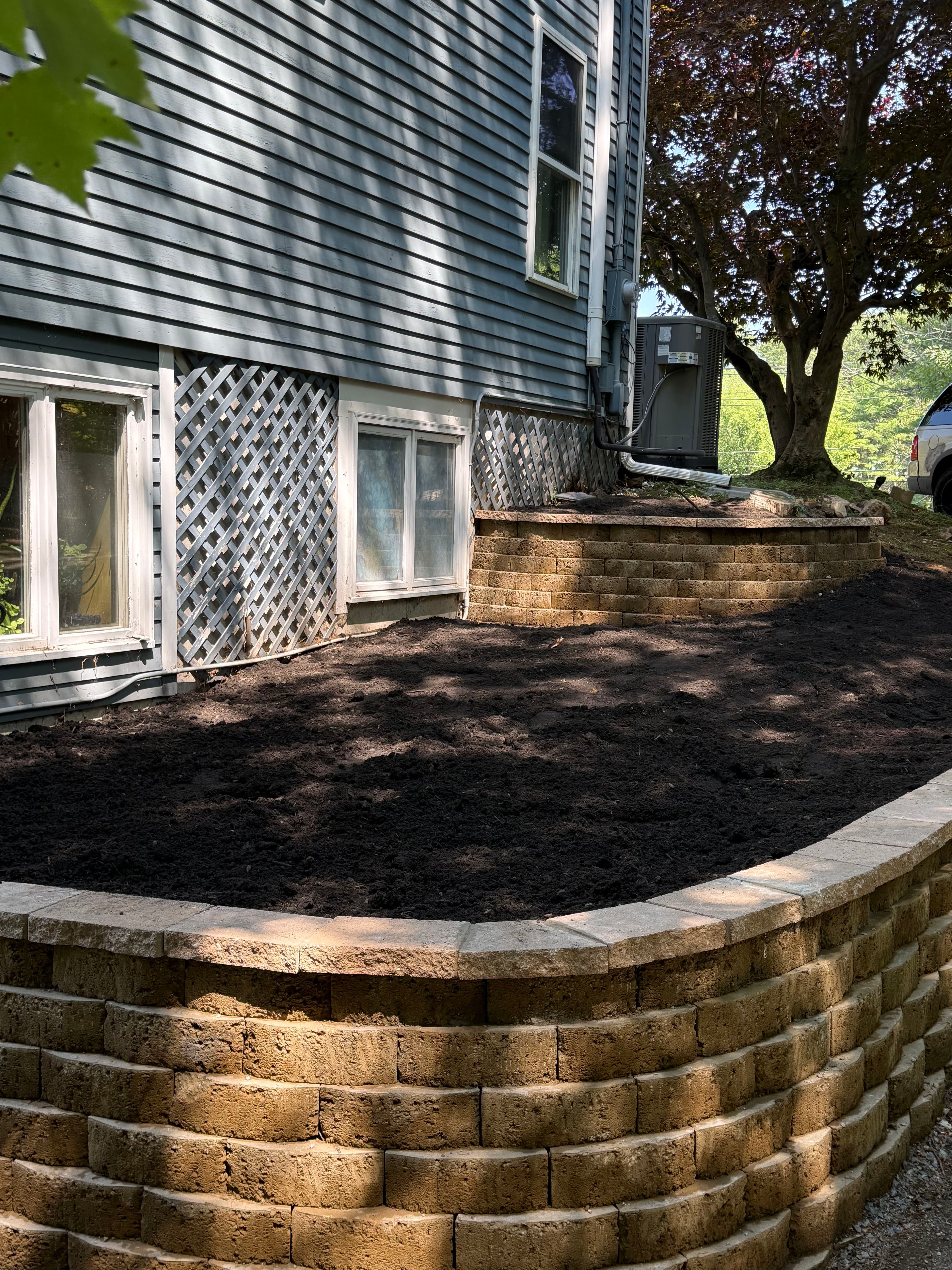 Project Retaining Wall Build With Fresh Loam and Cap Finish image